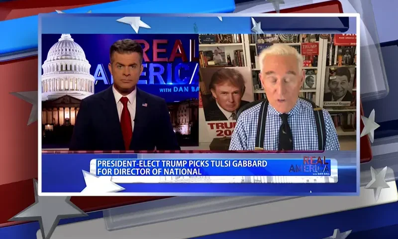 Video still from Real America on One America News Network showing a split screen of the host on the left side, and on the right side is the guest, Roger Stone.