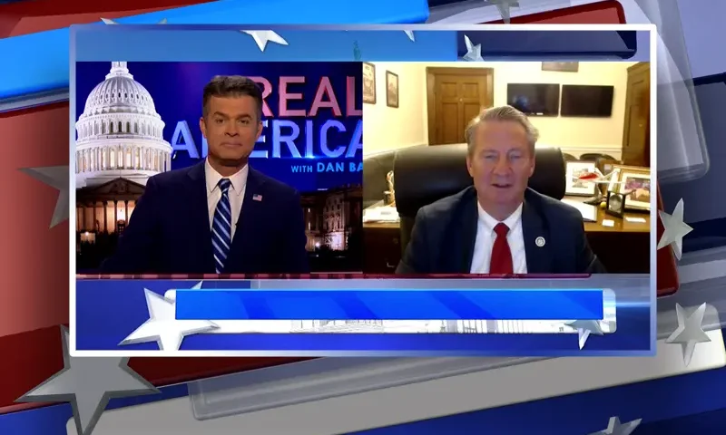 Video still from Real America on One America News Network showing a split screen of the host on the left side, and on the right side is the guest, Rep. Tim Burchett.