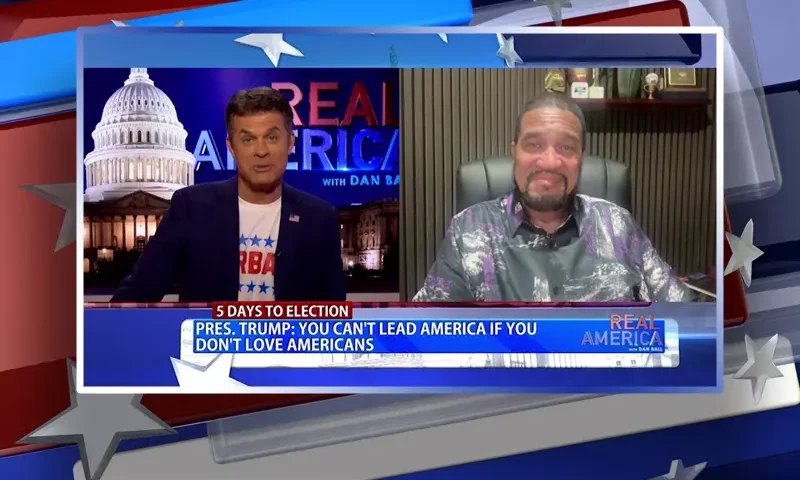Video still from Real America on One America News Network showing a split screen of the host on the left side, and on the right side is the guest, Darrell Scott.