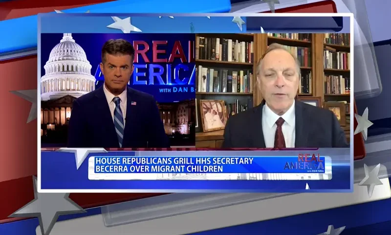 Video still from Real America on One America News Network showing a split screen of the host on the left side, and on the right side is the guest, Rep. Andy Biggs.