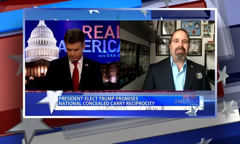 Video still from Real America on One America News Network showing a split screen of the host on the left side, and on the right side is the guest, Luis Valdes.