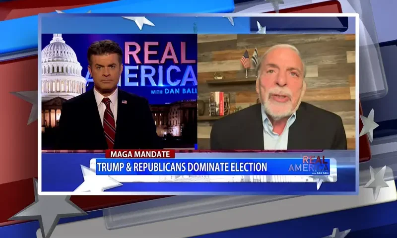 Video still from Real America on One America News Network showing a split screen of the host on the left side, and on the right side is the guest, Dov Hikind.