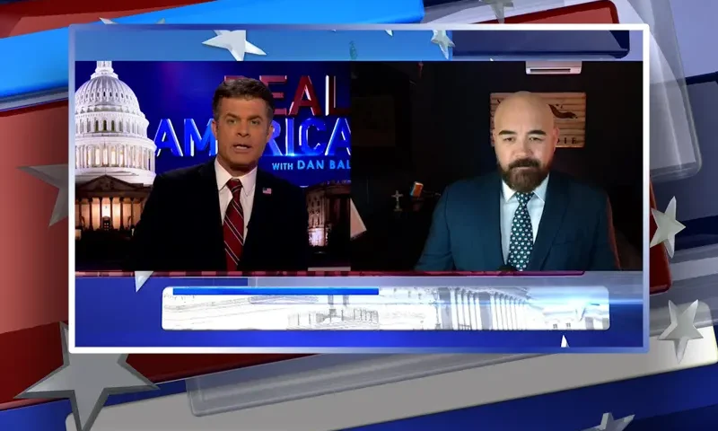 Video still from Real America on One America News Network showing a split screen of the host on the left side, and on the right side is the guest, Joseph McBride.