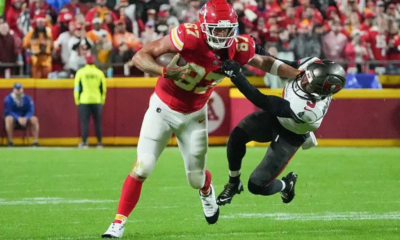 Kansas City Chiefs tight end Travis Kelce (87) runs the ball and stiff arms Tampa Bay Buccaneers safety Jordan Whitehead (3) during the first half at GEHA Field at Arrowhead Stadium. Mandatory Credit: Denny Medley-Imagn Images