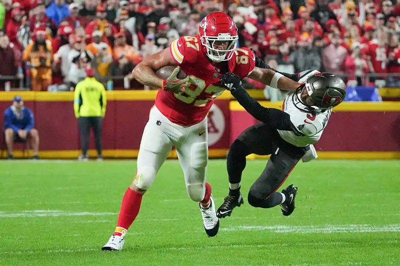 Kansas City Chiefs tight end Travis Kelce (87) runs the ball and stiff arms Tampa Bay Buccaneers safety Jordan Whitehead (3) during the first half at GEHA Field at Arrowhead Stadium. Mandatory Credit: Denny Medley-Imagn Images