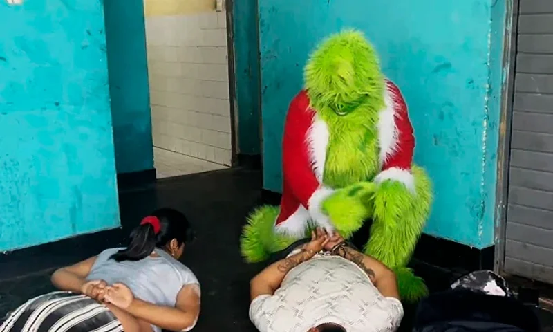 A police officer dressed The Grinch arrests suspected drug dealers in Lima, Peru, on December 23, 2024. Policia Nacional Del Peru / AFP - Getty Images