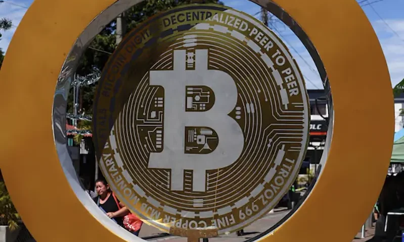 A woman passes by the Bitcoin Monument after bitcoin soared above $100,000, in Ilopango, El Salvador, December 5, 2024. REUTERS/Jose Cabezas/File Photo