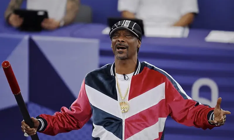 Snoop Dogg holds a baton to signal the official start of the competition. REUTERS/Angelika Warmuth/File Photo