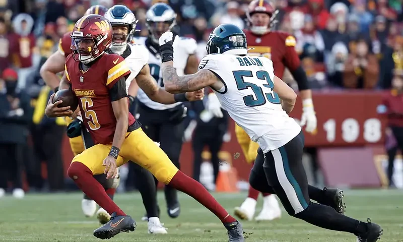 Washington Commanders quarterback Jayden Daniels (5) runs with the ball as Philadelphia Eagles linebacker Zack Baun (53) chases during the third quarter at Northwest Stadium. Mandatory Credit: Geoff Burke-Imagn Images