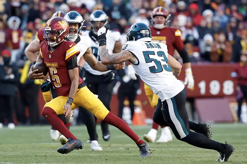 Washington Commanders quarterback Jayden Daniels (5) runs with the ball as Philadelphia Eagles linebacker Zack Baun (53) chases during the third quarter at Northwest Stadium. Mandatory Credit: Geoff Burke-Imagn Images