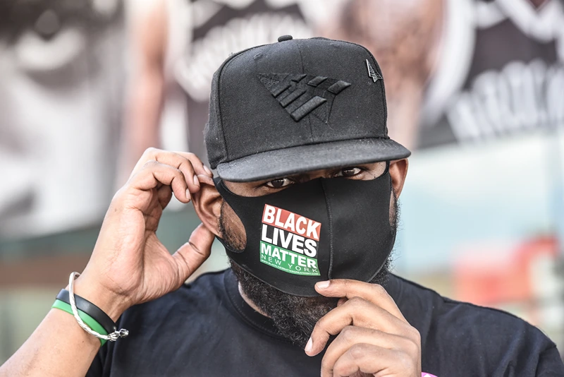 NEW YORK, NY - MAY 15: Hawk Newsome places a protective mask over his face before participating in a rally in front of the Barclays Center on May 15, 2020 in the Brooklyn borough in New York City. The rally protests alleged police brutality during social distancing enforcement. (Photo by Stephanie Keith/Getty Images)