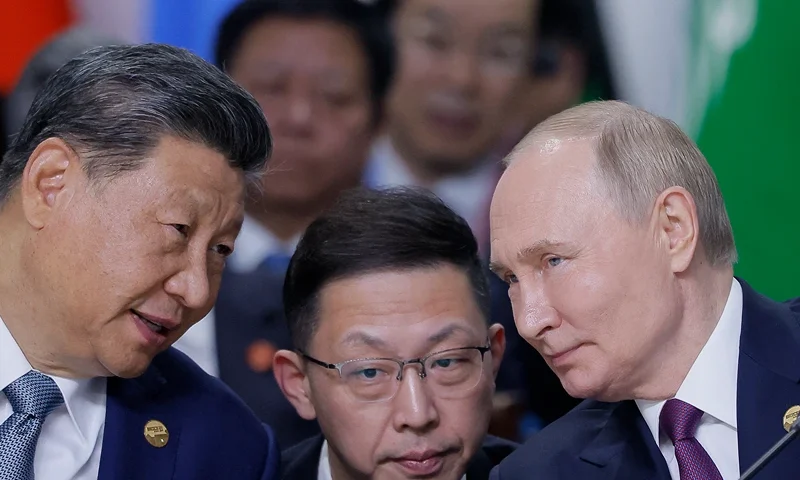Russian President Vladimir Putin and Chinese President Xi Jinping speak during a plenary session in the outreach/BRICS Plus format at the BRICS summit in Kazan on October 24, 2024. (Photo by Maxim Shemetov / POOL / AFP) (Photo by MAXIM SHEMETOV/POOL/AFP via Getty Images)