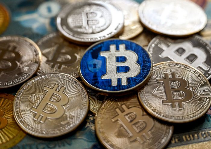 This illustration photograph taken on November 22, 2024 in Istanbul shows a coin imitation of the Bitcoin crypto currency arranged beside a screen displaying a trading chart. Most markets gained on November 22, 2024 after a bounce on Wall Street, while bitcoin continued its march higher to move within touching distance of the $100,000 mark. (Photo by Ozan KOSE / AFP) (Photo by OZAN KOSE/AFP via Getty Images)