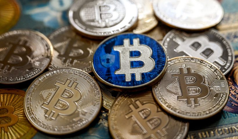 This illustration photograph taken on November 22, 2024 in Istanbul shows a coin imitation of the Bitcoin crypto currency arranged beside a screen displaying a trading chart. Most markets gained on November 22, 2024 after a bounce on Wall Street, while bitcoin continued its march higher to move within touching distance of the $100,000 mark. (Photo by Ozan KOSE / AFP) (Photo by OZAN KOSE/AFP via Getty Images)