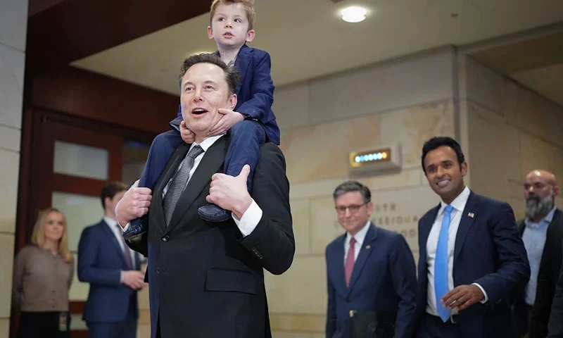 WASHINGTON, DC - DECEMBER 05: Tesla CEO Elon Musk, Co-Chair of the newly announced Department of Government Efficiency (DOGE) carries his son on his shoulders at the U.S. Capitol after a media availability with businessman Vivek Ramaswamy (2nd R), Co-Chair of the newly announced Department of Government Efficiency and Speaker of the House Mike Johnson (3rd R) (R-LA) on December 05, 2024 in Washington, DC. Musk and Ramaswamy are meeting with members of the U.S. Congress today about DOGE, a planned presidential advisory commission with the goal of cutting government spending and increasing efficiency in the federal workforce. ( (Photo by Andrew Harnik/Getty Images)