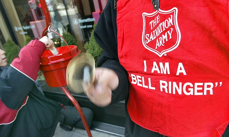 CHICAGO, NOVEMBER 21: A donation is made as Salvation Army bell ringer Ruben Rios works outside a store November 21, 2003 on the Magnificent Mile in Chicago. Funds raised through the Chicagoland bell ringing campaign will be used year-round to help feed the hungry, shelter the homeless, give help to the hurting and restore hope to the lost. Red Kettle funds help support 34 Salvation Army social service programs throughout the city and suburbs. (Photo by Tim Boyle/Getty Images)