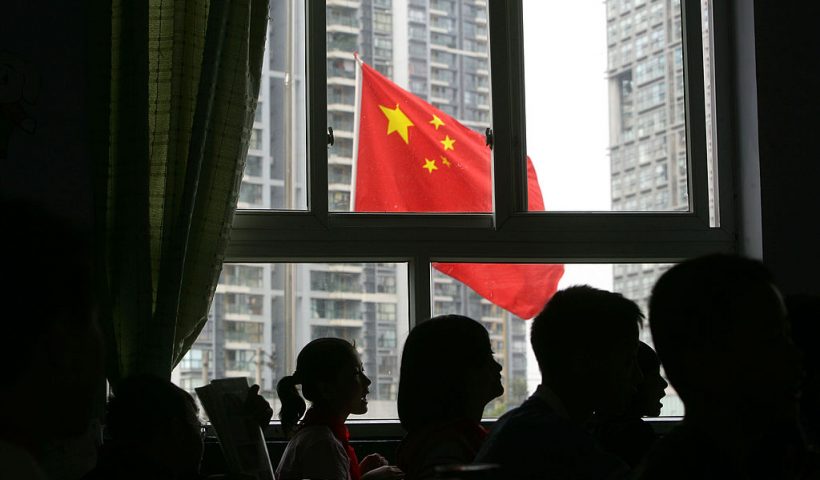 CHENGDU, CHINA - MAY 19: (CHINA OUT) Students look at a Chinese national flag flying at half-mast from a school classroom as China begins three days of national mourning for victim of the earthquake on May 19, 2008 in Chengdu, Sichuan province, China. The period of mourning will include a three minute silence which will be observed exactly one week after the earthquake hit. A major earthquake measuring 8.0 on the Richter scale, the worst in 58 years, jolted China's Sichuan Province May 12. The death toll is now estimated at over 32,000 people and is expected to rise, as 100,000 military troops continue rescue operations. (Photo by China Photos/Getty Images)