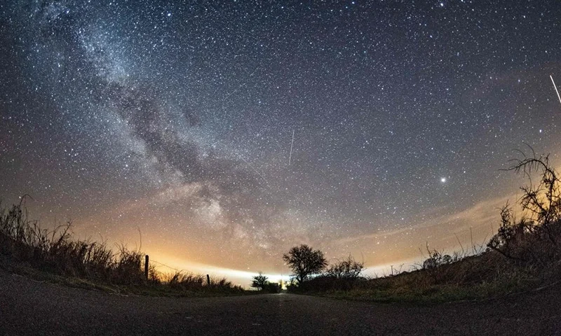 TOPSHOT - The milky way and meteors of the April Lyrids annual meteor shower are seen in the night sky over Burg auf Fehmarn on the Baltic Sea island of Fehmarn, northern Germany, on April 20, 2018. - Germany OUT (Photo by Daniel Reinhardt / dpa / AFP) / Germany OUT (Photo by DANIEL REINHARDT/dpa/AFP via Getty Images)