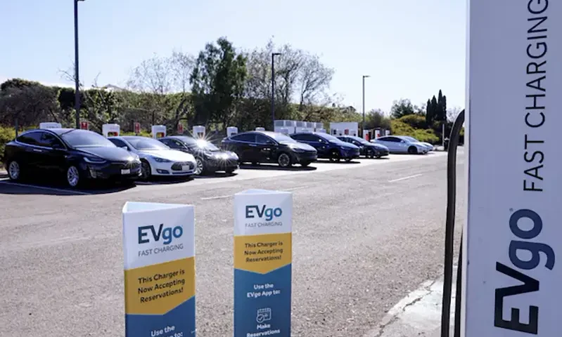 People charge their electric cars at a Tesla super charging station next to an EVgo electric charging location in Carlsbad, California, U.S., March 7, 2022. REUTERS/Mike Blake/File Photo