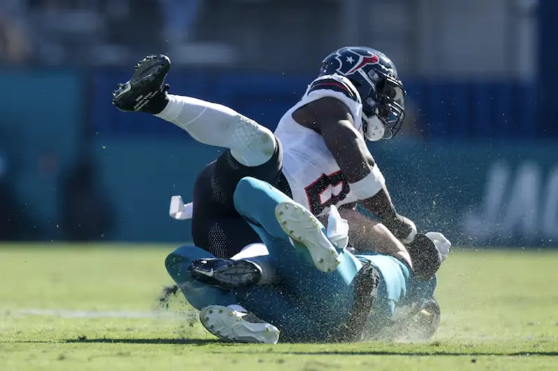 Jacksonville Jaguars quarterback Trevor Lawrence (16) is hit by Houston Texans linebacker Azeez Al-Shaair (0) as he slides down in the second quarter in the second quarter at EverBank Stadium. Mandatory Credit: Nathan Ray Seebeck-Imagn Images/File Photo