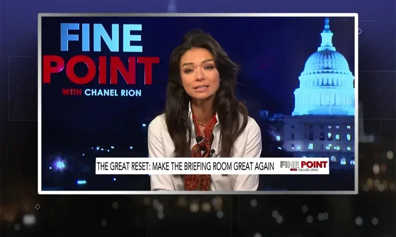 Video still of the host of Fine Point at the desk of their talk show on One America News Network.