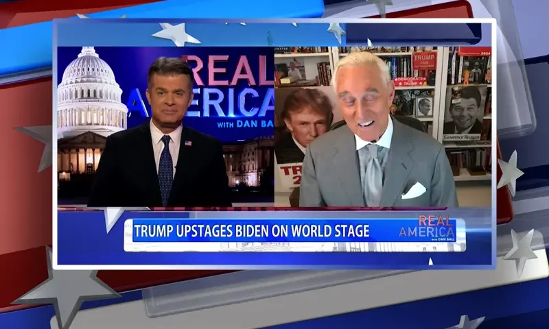 Video still from Real America on One America News Network showing a split screen of the host on the left side, and on the right side is the guest, Roger Stone.