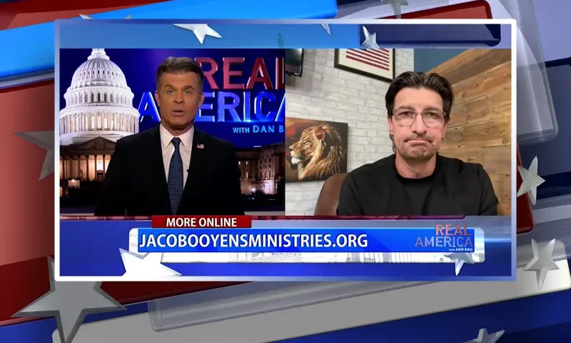 Video still from Real America on One America News Network showing a split screen of the host on the left side, and on the right side is the guest, Jaco Booyens.