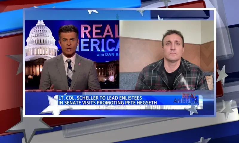 Video still from Real America on One America News Network showing a split screen of the host on the left side, and on the right side is the guest, Stuart Scheller.
