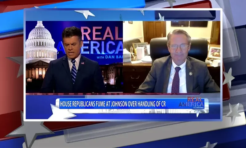 Video still from Real America on One America News Network showing a split screen of the host on the left side, and on the right side is the guest, Rep. Tim Burchett.