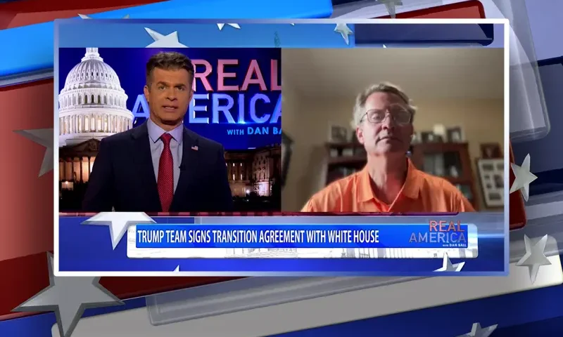 Video still from Real America on One America News Network showing a split screen of the host on the left side, and on the right side is the guest, Rep. Tim Burchett.
