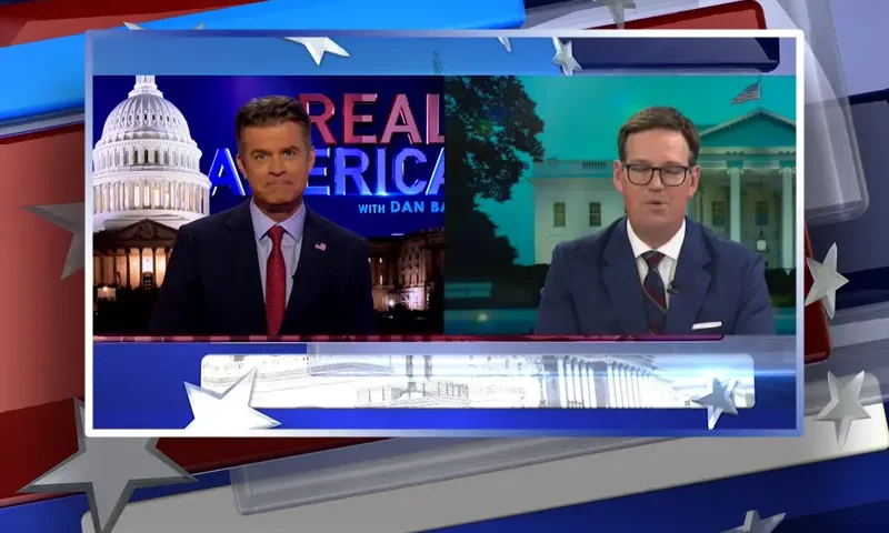 Video still from Real America on One America News Network showing a split screen of the host on the left side, and on the right side is the guest, Fletcher Gill.
