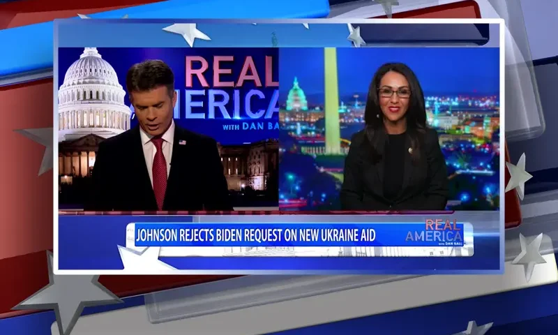 Video still from Real America on One America News Network showing a split screen of the host on the left side, and on the right side is the guest, Rep. Lauren Boebert.