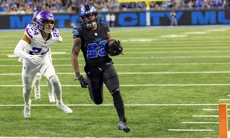 Detroit Lions running back Jahmyr Gibbs (26) runs with the ball in front of Minnesota Vikings safety Camryn Bynum (24) and scores a touchdown during the second half at Ford Field. Mandatory Credit: David Reginek-Imagn Images