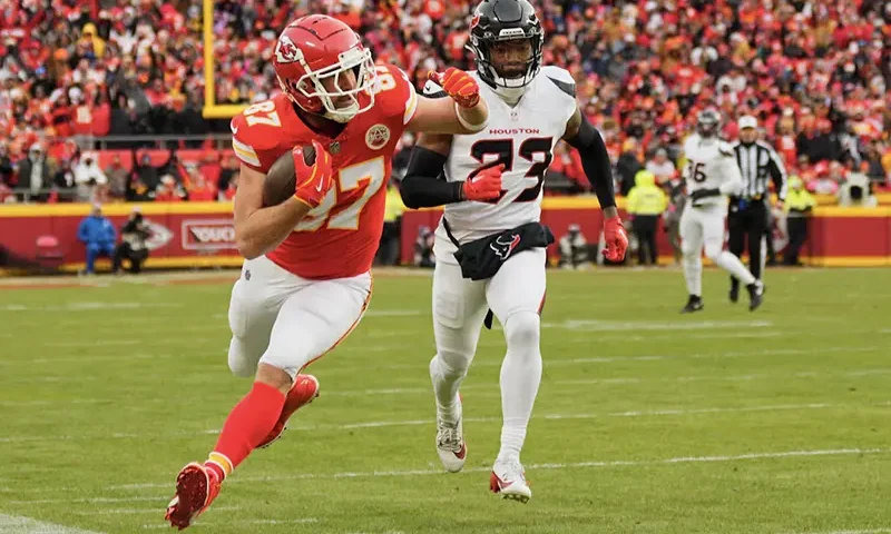 Kansas City Chiefs tight end Travis Kelce (87) runs to the sideline after a pass reception against Houston Texans safety Eric Murray (23) during the first quarter of a 2025 AFC divisional round game at GEHA Field at Arrowhead Stadium. Mandatory Credit: Jay Biggerstaff-Imagn Images