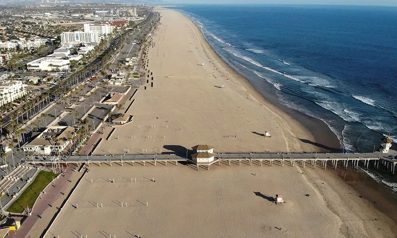 HUNTINGTON BEACH, CALIFORNIA - MARCH 28: An aerial view of Huntington Beach and its shuttered pier amid the coronavirus pandemic on March 28, 2020 in Huntington Beach, California. The city of Huntington Beach has closed its pier and parking lots along the beach in efforts to limit the spread of COVID-19 although the beach itself remains open. (Photo by Mario Tama/Getty Images)