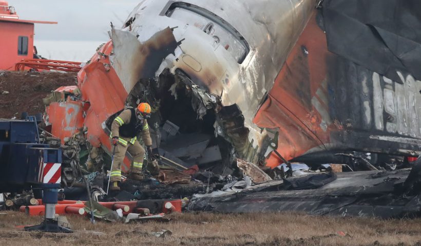 MUAN-GUN, SOUTH KOREA - DECEMBER 30: Firefighters work at the wreckage of a passenger plane at Muan International Airport on December 30, 2024 in Muan-gun, South Korea. A plane carrying 181 people, Jeju Air Flight 7C2216, crashed at Muan International Airport in South Korea after skidding off the runway and colliding with a wall, resulting in an explosion. Early reports said that at least 179 people had died. (Photo by Chung Sung-Jun/Getty Images)