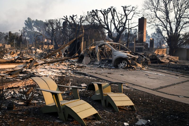 TOPSHOT - Melted lawn chairs are seen near the remains of a burnt home after the passage of the Palisades Fire in Pacific Palisades, California, on January 8, 2025. At least five people have been killed in wildfires rampaging around Los Angeles, officials said on January 8, with firefighters overwhelmed by the speed and ferocity of multiple blazes. (Photo by AGUSTIN PAULLIER / AFP) (Photo by AGUSTIN PAULLIER/AFP via Getty Images)