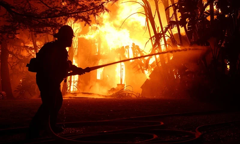 ALTADENA, CALIFORNIA - JANUARY 08: Los Angeles County firefighters spray water on a burning home as the Eaton Fire moved through the area on January 08, 2025 in Altadena, California. Fueled by intense Santa Ana Winds, the Palisades Fire has grown to over 2,900 acres and 30,000 people have been ordered to evacuate while a second fire has emerged near Eaton Canyon in Altadena. (Photo by Justin Sullivan/Getty Images)