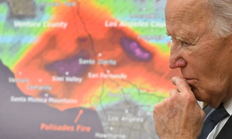 A map of the Palisades and Eaton Fires is displayed as US President Joe Biden listens to a report during a briefing on the federal response to the wildfires across Los Angeles in the Roosevelt Room of the White House in Washington, DC, on January 13, 2025. (Photo by ROBERTO SCHMIDT/AFP via Getty Images)