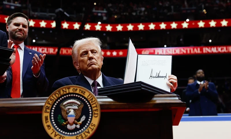 WASHINGTON, DC - JANUARY 20: U.S. President Donald Trump holds up an executive orders after signing it during an indoor inauguration parade at Capital One Arena on January 20, 2025 in Washington, DC. Donald Trump takes office for his second term as the 47th president of the United States. (Photo by Anna Moneymaker/Getty Images)