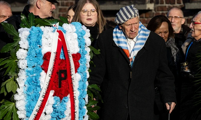 Survivors of the Auschwitz concentration camp and their families arrive to lay candles at the so-called "Death Wall" at the Auschwitz I former concentration camp site on the 80th anniversary of the liberation of the camp on January 27, 2025, in Oswiecim, Poland. The Nazis built and operated the Auschwitz complex of concentration camps during World War II initially for slave labor and later for the mass extermination of Jews and other undesirables. Approximately 1.1 million people died at Auschwitz, most of them in the notorious gas chambers of Auschwitz II-Birkenau. The Soviet Army liberated the camp in 1945. (Photo by Bob Reijnders / Middle East Images / Middle East Images via AFP) (Photo by BOB REIJNDERS/Middle East Images/AFP via Getty Images)