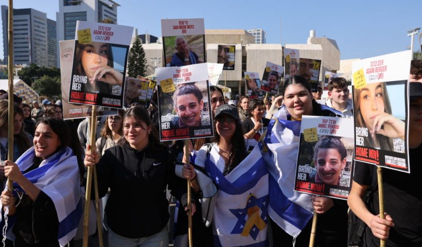 Demonstrators raise placards as they celebrate the release of three hostages held captive in Gaza since the October 7, 2023 attack by Palestinian militants, in Tel Aviv on January 30, 2025. Israel and Hamas were set to carry out their third hostage-prisoner exchange on January 30, with three Israelis and five Thai captives slated for release as part of a ceasefire deal aimed at ending the Gaza war. (Photo by Menahem KAHANA / AFP) (Photo by MENAHEM KAHANA/AFP via Getty Images)