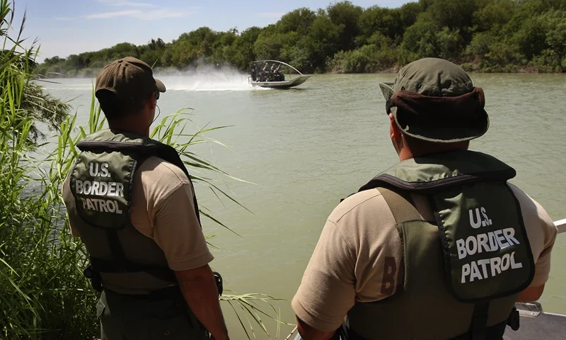 LAREDO, TX - AUGUST 07: U.S. Border Patrol agents watch colleagues motor past while patrolling for illegal immigrants in the Rio Grande River crossing into the United States August 7, 2008 near Laredo, Texas. Agents in the Laredo sector of the border travel the Rio Grande River in six 18" Diamondback airboats as part of their efforts to stop illegal immigrants, drug traffickers and terrorists from crossing illegally into the United States. Securing the nation's borders is an important topic in this year's presidential campaign. Since 9/11, the Border Patrol has grown by about a third to more than 15,000 agents. (Photo by John Moore/Getty Images)