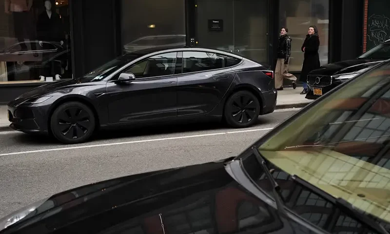 People walk past a Tesla car parked in the Meatpacking District of New York City, U.S., January 02, 2025. REUTERS/Adam Gray/File Photo