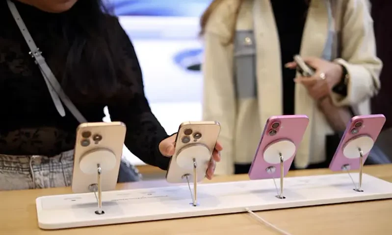 Women use Apple iPhone smartphones displayed at a store in London, Britain, October 6, 2024. REUTERS/Hollie Adams/File Photo