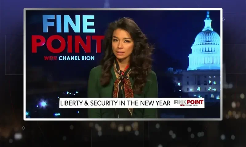 Video still of the host of Fine Point at the desk of their talk show on One America News Network.