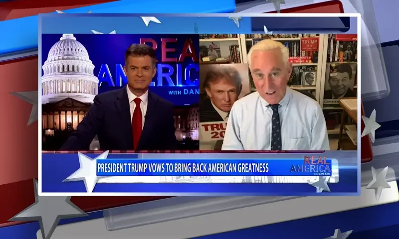 Video still from Real America on One America News Network showing a split screen of the host on the left side, and on the right side is the guest, Roger Stone.