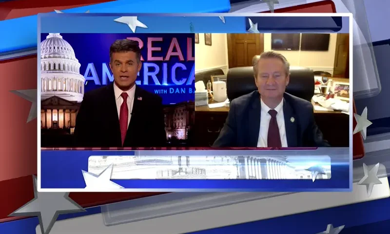Video still from Real America on One America News Network showing a split screen of the host on the left side, and on the right side is the guest, Rep. Tim Burchett.