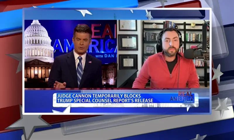 Video still from Real America on One America News Network showing a split screen of the host on the left side, and on the right side is the guest, Josh Hammer.