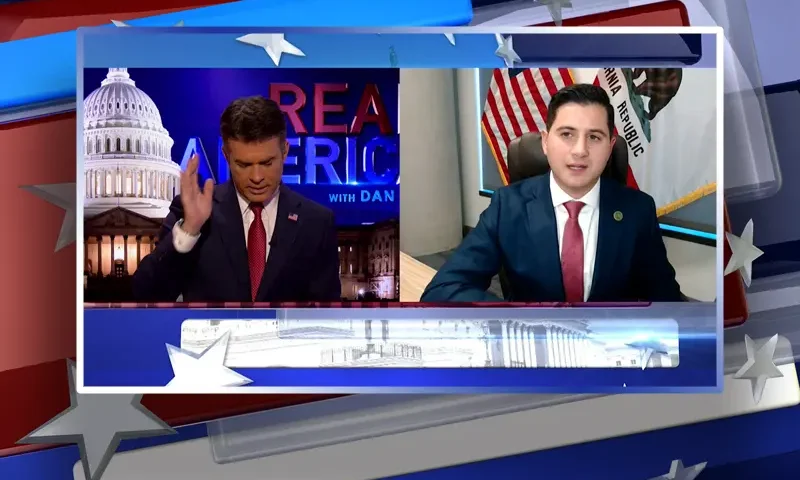 Video still from Real America on One America News Network showing a split screen of the host on the left side, and on the right side is the guest, Bill Essayli.